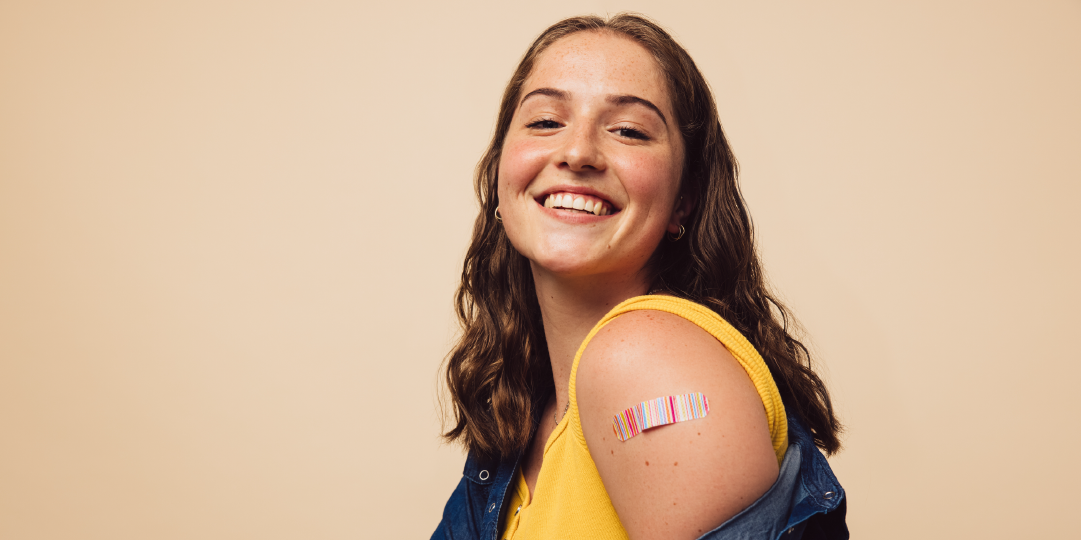 teenage girl smiling after getting a vaccine