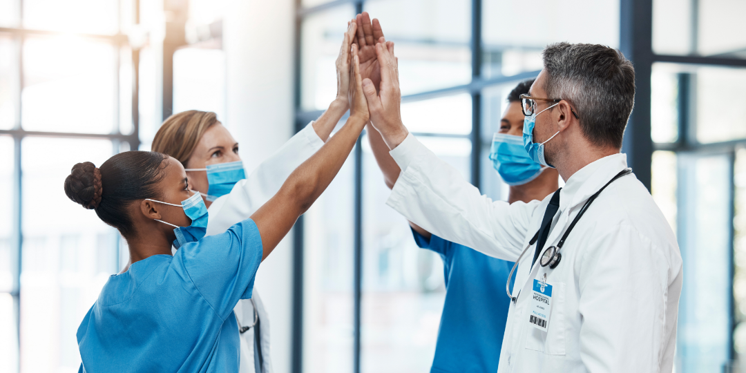 team of medical providers high fiving 