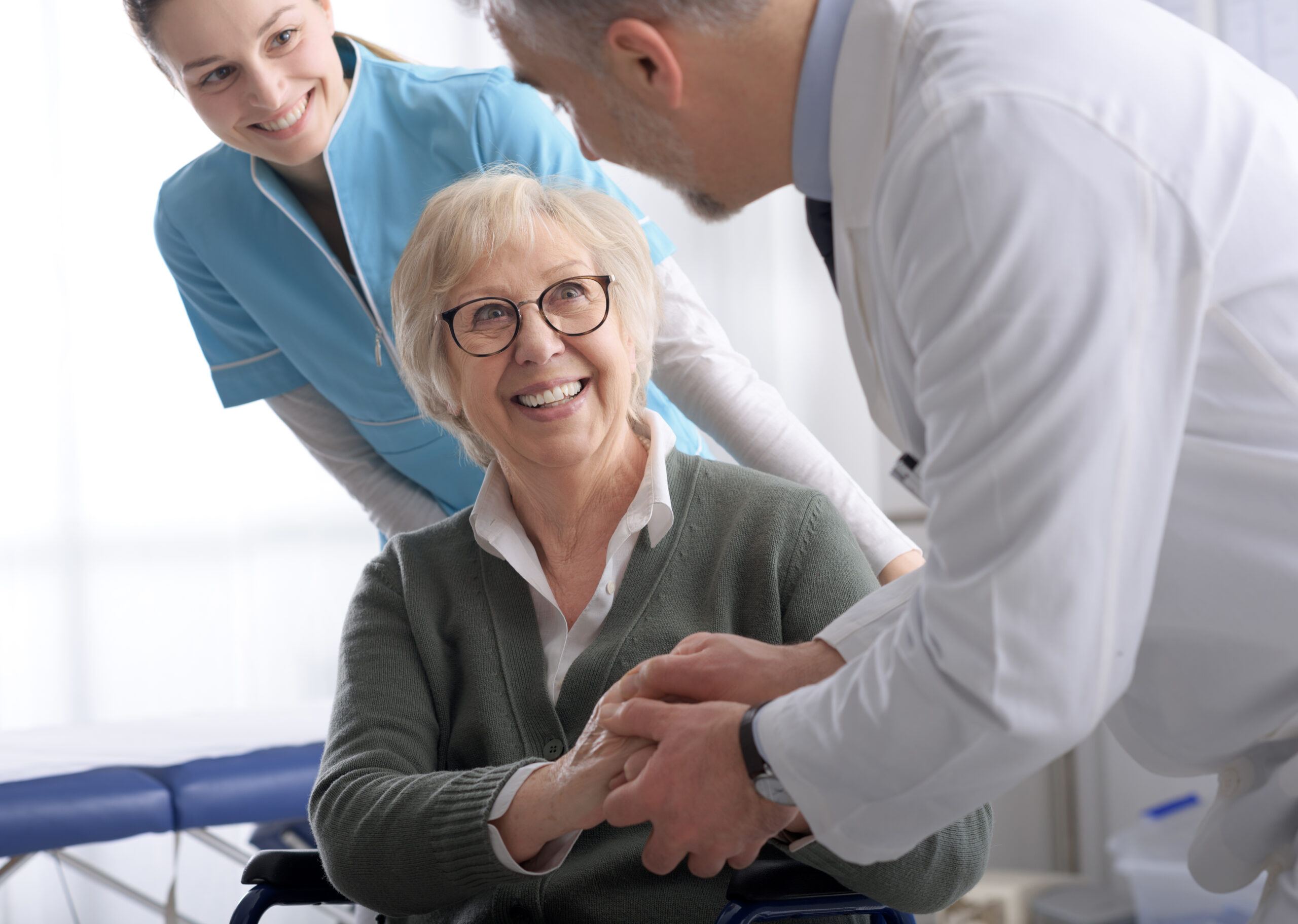Doctor and senior patient shaking hands in the office doctor with a senior female patient