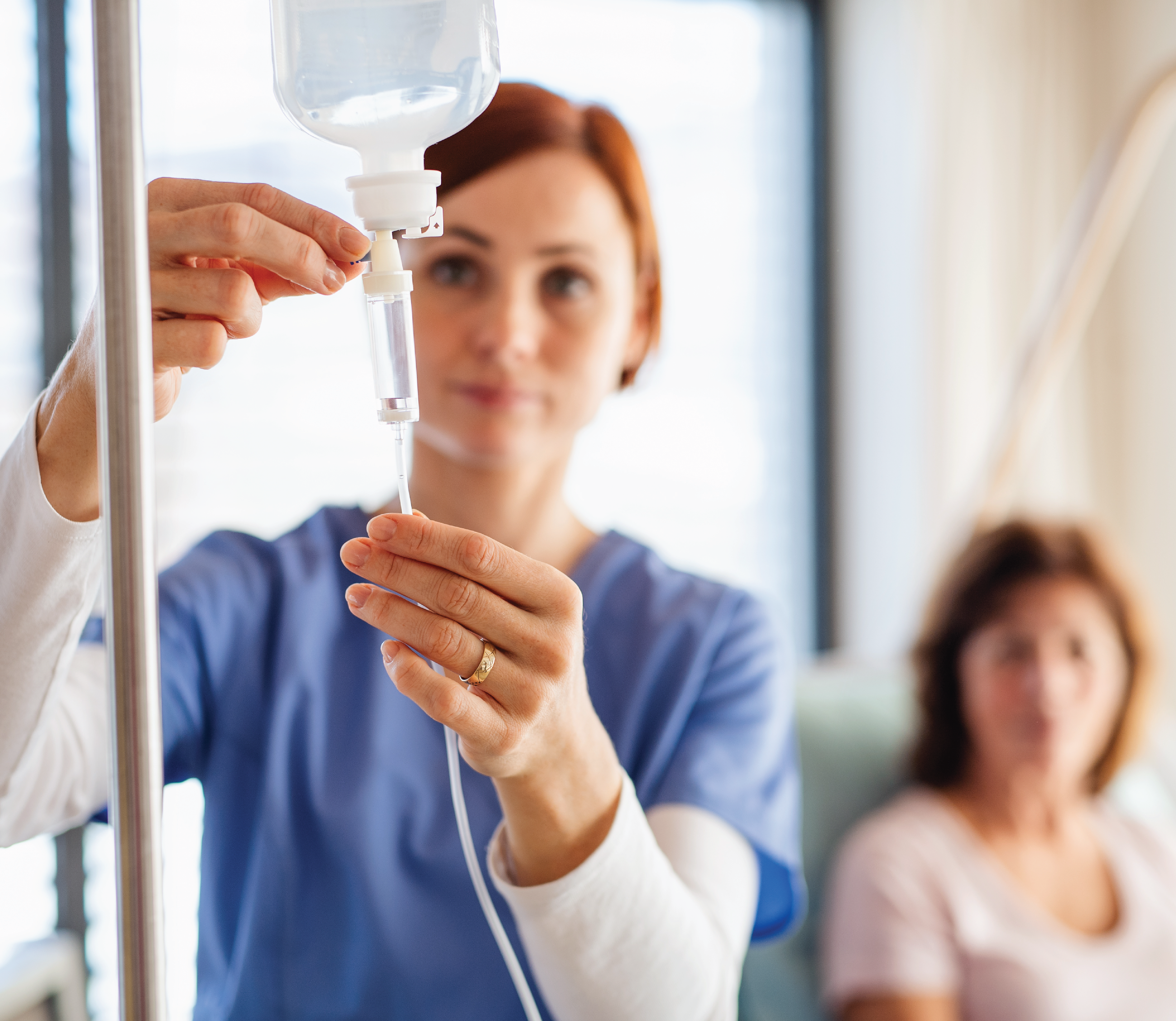 nurse setting up a patient's vitamin IV drip 