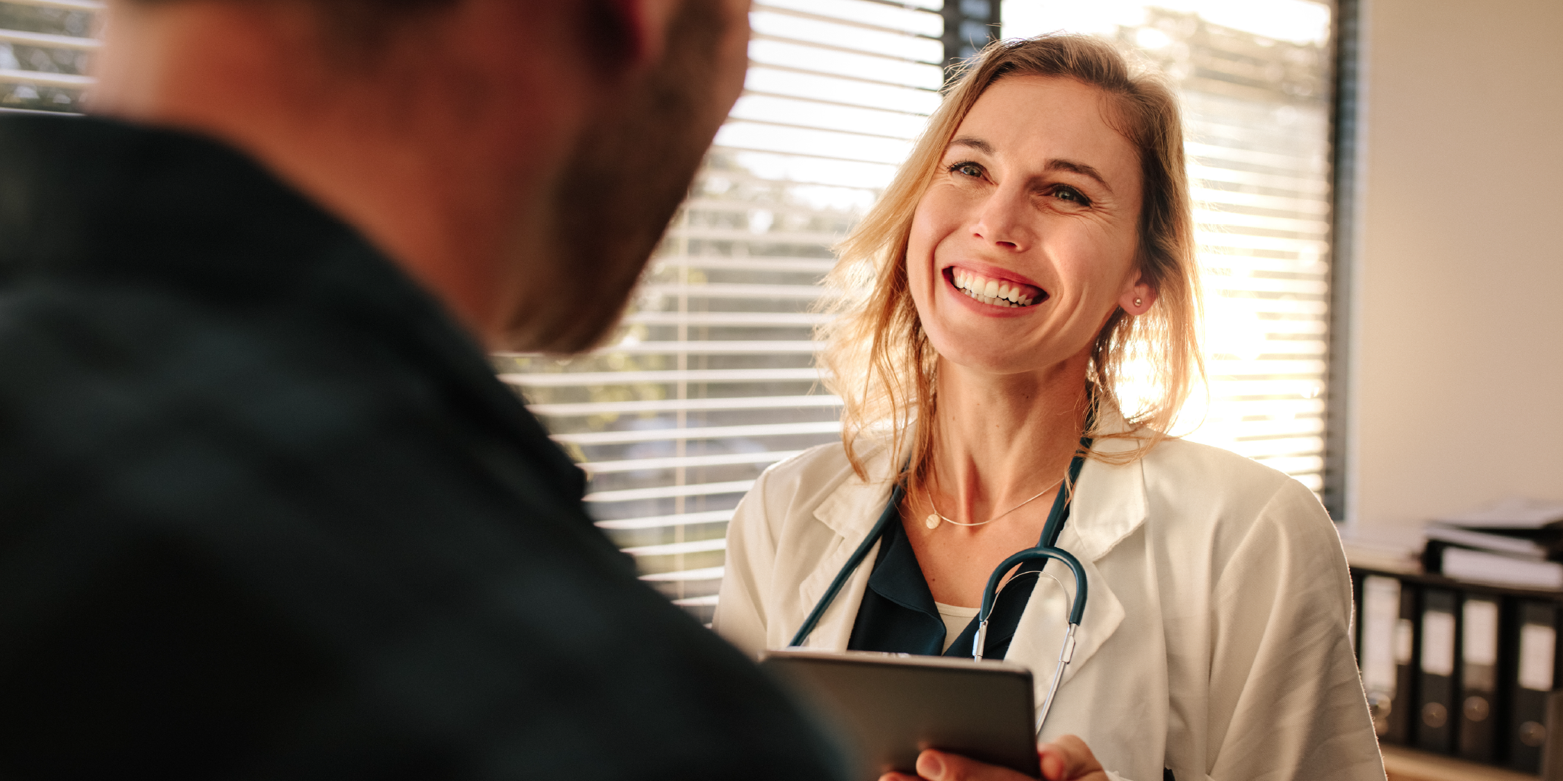 smiling doctor speaking to a patient 